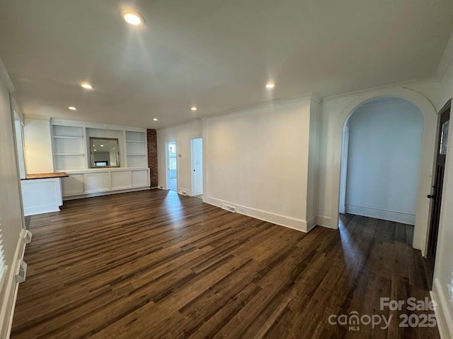 1019 Valley St, Kannapolis, NC 28081 - unfurnished living room with arched walkways, dark wood-type flooring, ornamental molding, recessed lighting, and baseboards