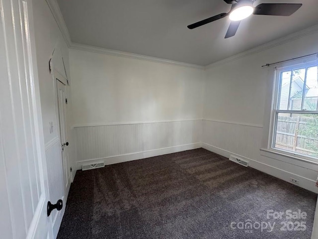 1019 Valley St, Kannapolis, NC 28081 - spare room featuring wainscoting, dark colored carpet, a ceiling fan, and ornamental molding