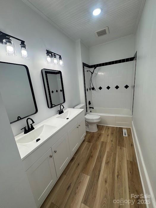 1019 Valley St, Kannapolis, NC 28081 - full bathroom with toilet, wood finished floors, shower / tub combination, and double vanity