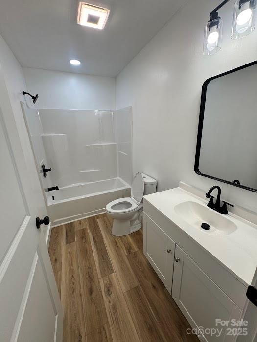 1019 Valley St, Kannapolis, NC 28081 - full bathroom featuring wood finished floors, toilet, vanity, and shower / bath combination