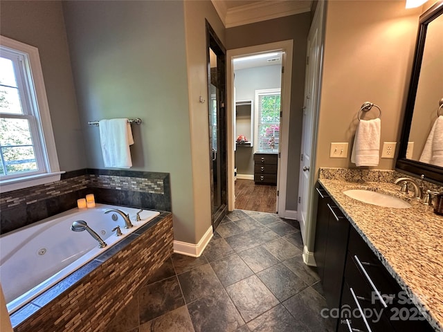 full bath with a jetted tub, a walk in closet, baseboards, vanity, and ornamental molding