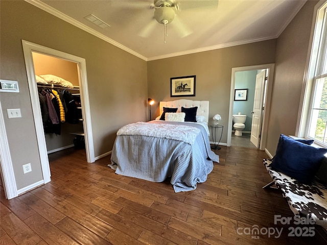 bedroom featuring visible vents, crown molding, a spacious closet, and hardwood / wood-style flooring
