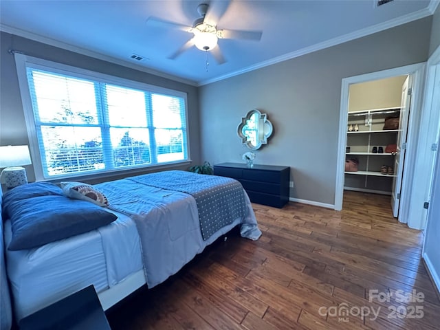 bedroom featuring crown molding, baseboards, and wood finished floors