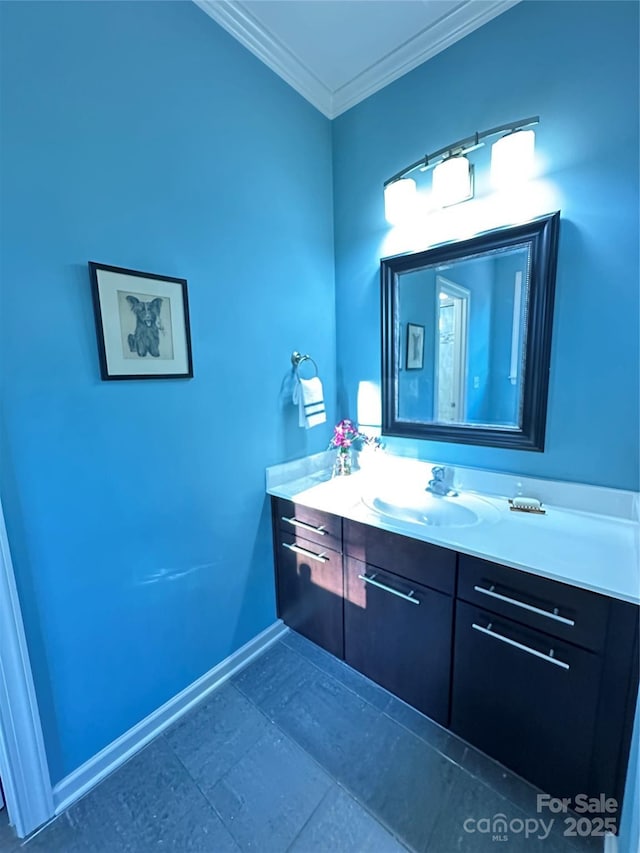 bathroom with baseboards, ornamental molding, and vanity