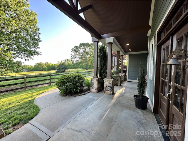 view of patio / terrace featuring fence and a rural view