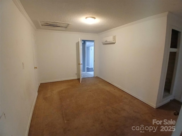carpeted empty room featuring baseboards, a textured ceiling, crown molding, and a wall unit AC