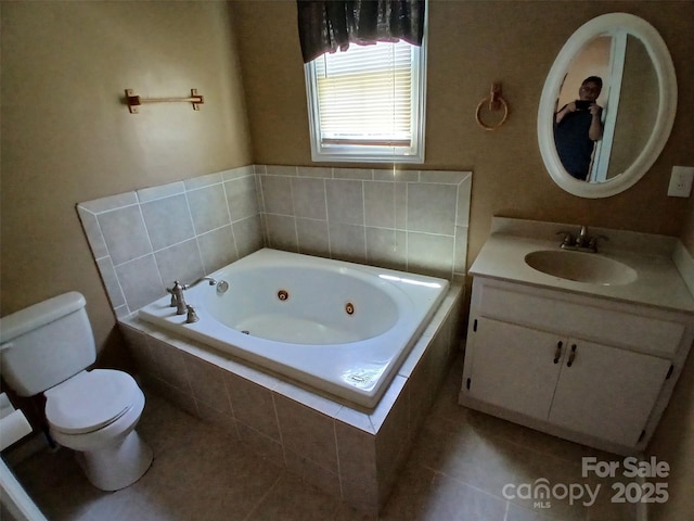 full bath with vanity, tile patterned floors, toilet, and a jetted tub