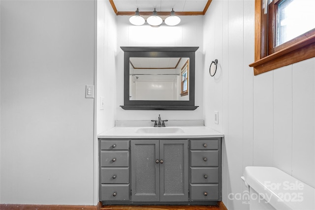 bathroom with crown molding, vanity, and toilet