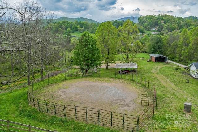 surrounding community with an enclosed area, an exterior structure, a mountain view, an outdoor structure, and a rural view