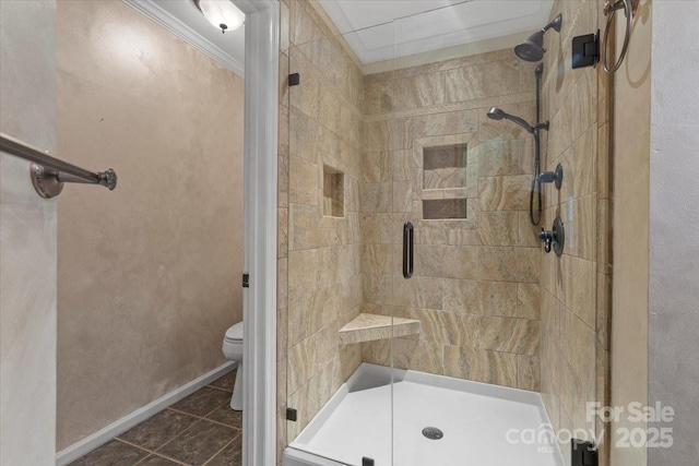 full bathroom with a shower stall, crown molding, baseboards, toilet, and tile patterned floors