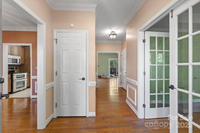 corridor featuring wood finished floors, french doors, and crown molding