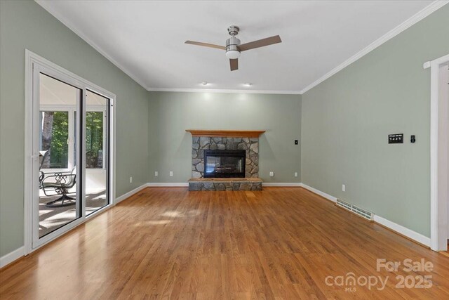 unfurnished living room featuring visible vents, wood finished floors, ceiling fan, and ornamental molding