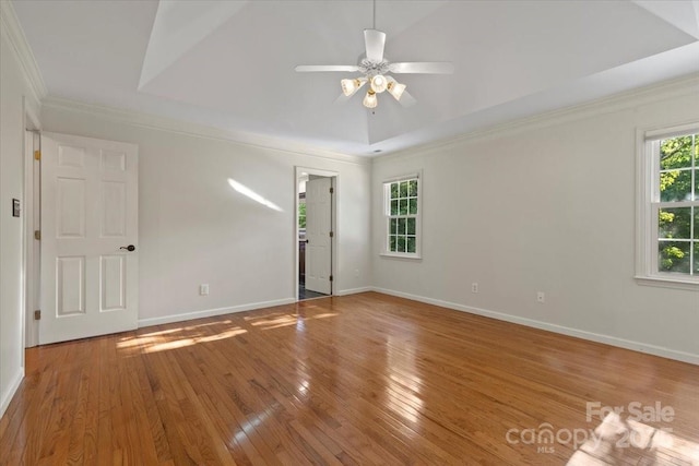unfurnished room with baseboards, hardwood / wood-style flooring, ceiling fan, and crown molding