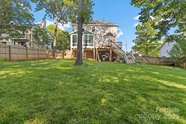 back of house featuring a lawn, a deck, stairway, and a fenced backyard
