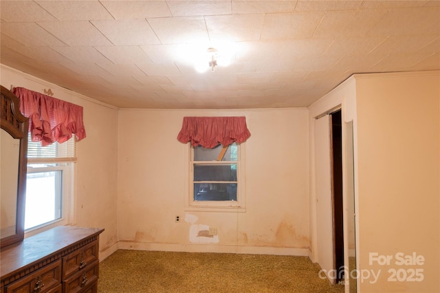 carpeted spare room featuring ornamental molding and baseboards