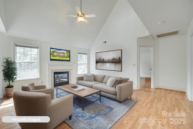 1835 Montague Rd, Clover, SC 29710 - living room with high vaulted ceiling, baseboards, a glass covered fireplace, ceiling fan, and light wood-style flooring