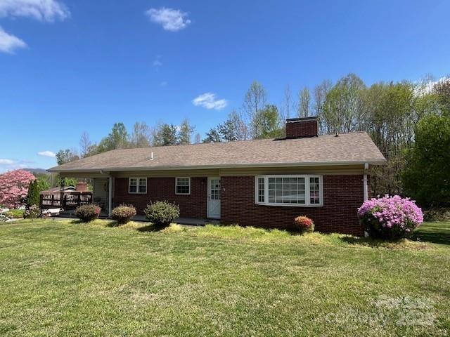 323 Hibriten Dr SE, Lenoir, NC 28645 - rear view of house featuring a chimney, a yard, and brick siding