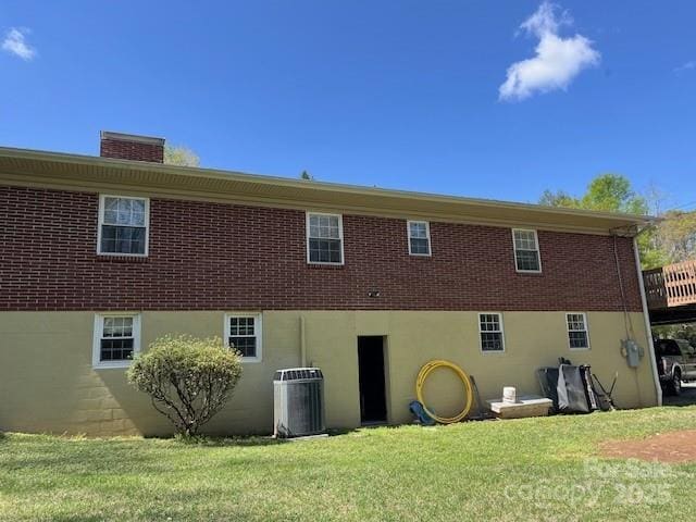 323 Hibriten Dr SE, Lenoir, NC 28645 - back of property featuring a yard, a chimney, cooling unit, and brick siding