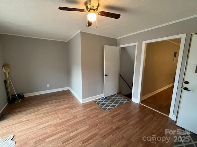 323 Hibriten Dr SE, Lenoir, NC 28645 - unfurnished bedroom with crown molding, a ceiling fan, baseboards, and wood finished floors