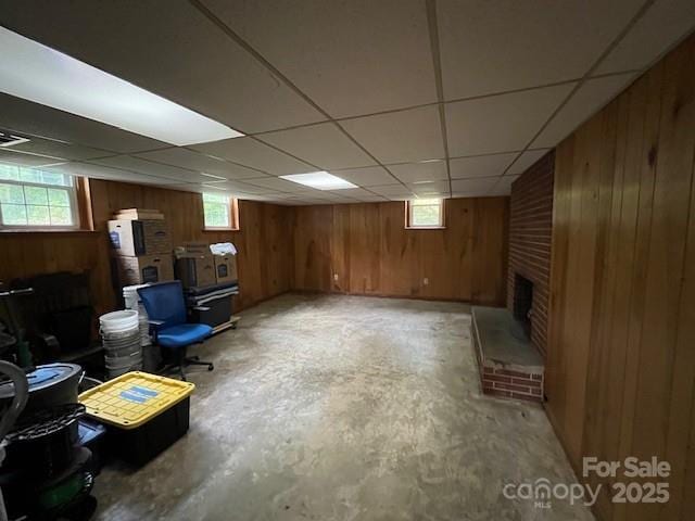323 Hibriten Dr SE, Lenoir, NC 28645 - basement featuring a healthy amount of sunlight, a drop ceiling, a brick fireplace, and wood walls