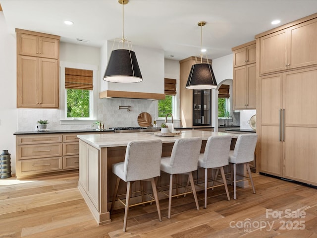 8044 Edgewater Dr Unit 100, Norwood, NC 28128 - kitchen with a center island with sink, tasteful backsplash, light wood-style floors, recessed lighting, and a kitchen breakfast bar