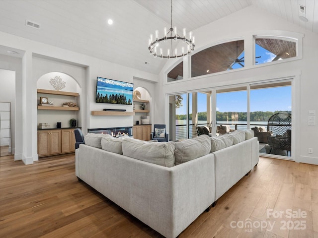 8044 Edgewater Dr Unit 100, Norwood, NC 28128 - living room with light wood-style floors, ceiling fan, a chandelier, built in shelves, and high vaulted ceiling
