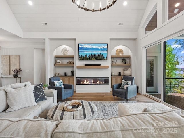 8044 Edgewater Dr Unit 100, Norwood, NC 28128 - living room with lofted ceiling, wood finished floors, built in features, a glass covered fireplace, and recessed lighting
