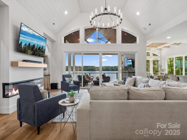 8044 Edgewater Dr Unit 100, Norwood, NC 28128 - living room featuring a chandelier, light wood finished floors, a glass covered fireplace, recessed lighting, and high vaulted ceiling