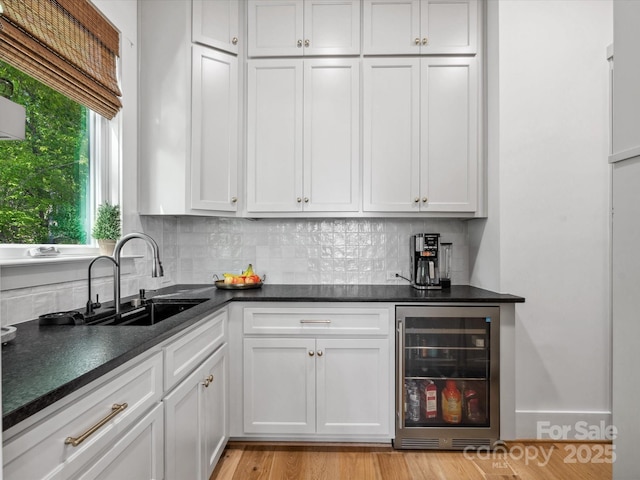 8044 Edgewater Dr Unit 100, Norwood, NC 28128 - kitchen with beverage cooler, a sink, dark countertops, and backsplash