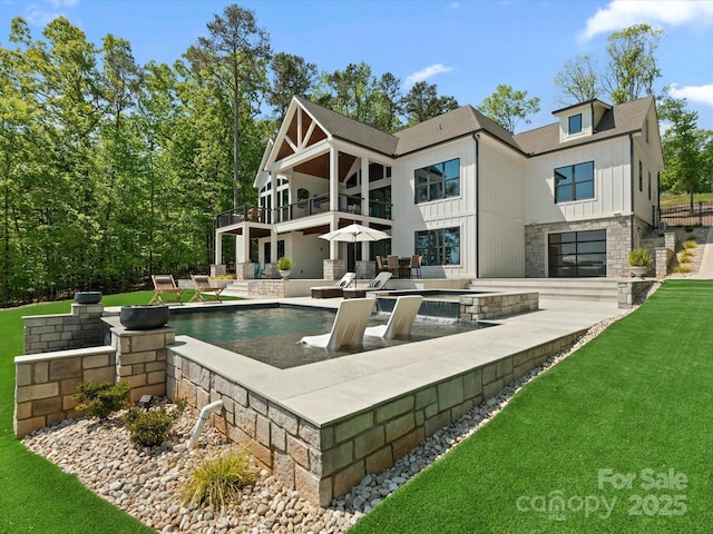 8044 Edgewater Dr Unit 100, Norwood, NC 28128 - back of house with a balcony, a patio, an outdoor pool, and a lawn