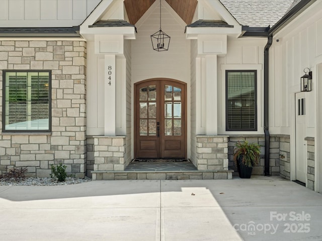 8044 Edgewater Dr Unit 100, Norwood, NC 28128 - property entrance featuring stone siding, board and batten siding, french doors, and a shingled roof