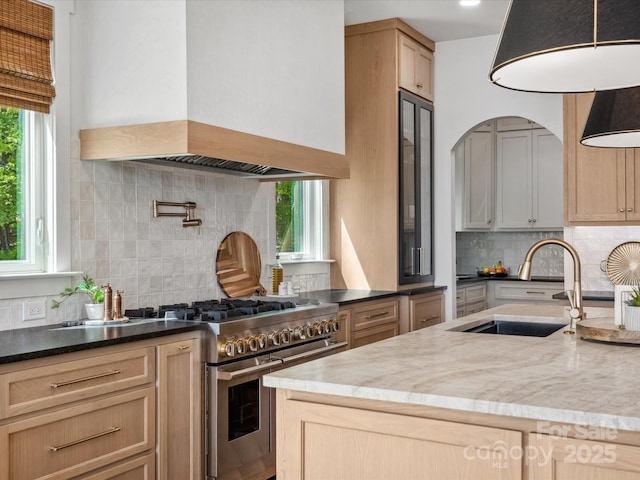 8044 Edgewater Dr Unit 100, Norwood, NC 28128 - kitchen with premium range hood, a sink, range with two ovens, and backsplash