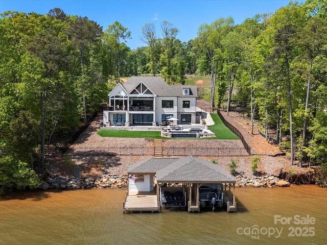 8044 Edgewater Dr Unit 100, Norwood, NC 28128 - dock with boat lift, a water view, and a view of trees