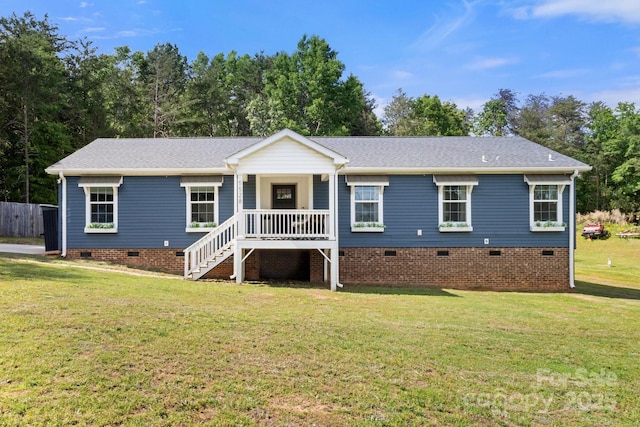 ranch-style home featuring covered porch, a front yard, a shingled roof, crawl space, and stairway