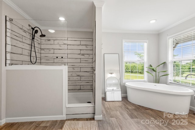 bathroom with crown molding, a soaking tub, tiled shower, and wood finished floors