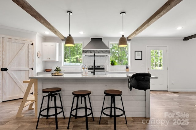 kitchen with electric stove, premium range hood, a wealth of natural light, and beamed ceiling
