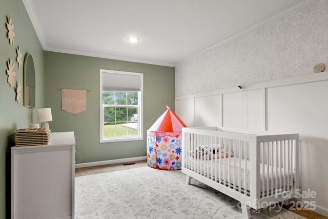 carpeted bedroom with crown molding, wainscoting, a crib, baseboards, and visible vents