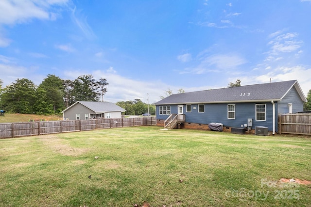 view of yard with a fenced backyard and central AC unit