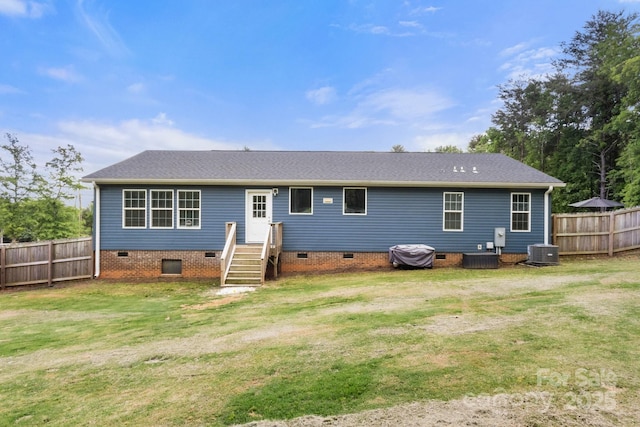 rear view of property featuring fence, a lawn, central AC, and crawl space