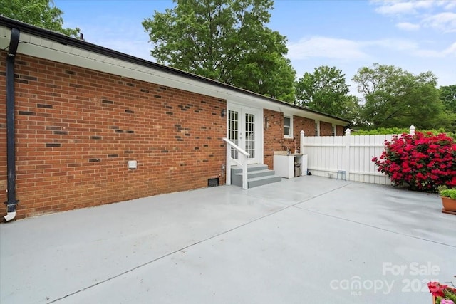324 Autumn Dr, Harrisburg, NC 28075 - rear view of house with brick siding, fence, entry steps, a patio area, and french doors