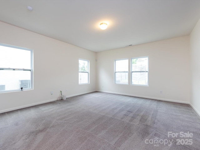 empty room featuring carpet and baseboards
