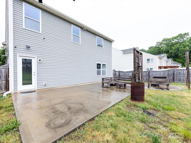 back of house with a patio, fence, and a lawn