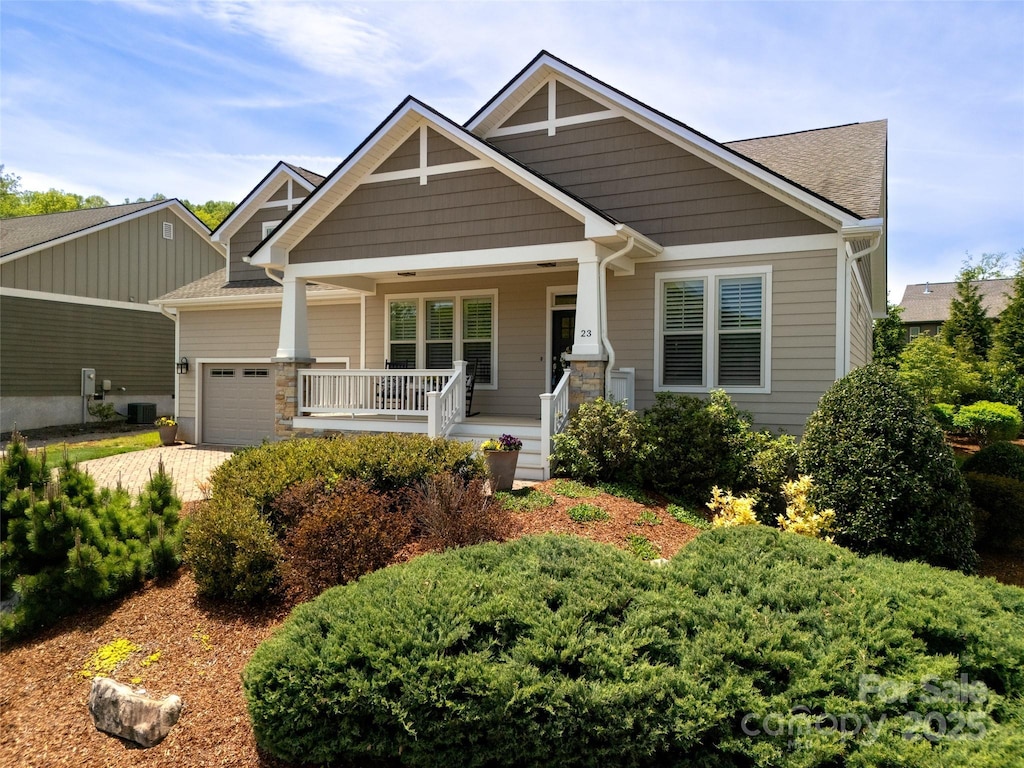 23 Estatoe Gap Rd, Biltmore Lake, NC 28715 - craftsman-style home featuring a garage, a shingled roof, a porch, central air condition unit, and driveway