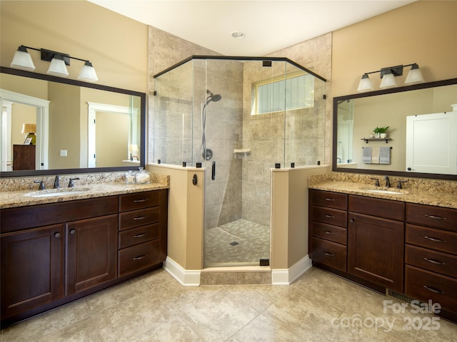 bathroom with a sink, a stall shower, tile patterned floors, and two vanities
