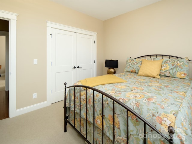bedroom with carpet floors, baseboards, and a closet