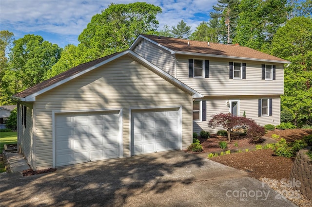 colonial inspired home featuring a garage and aphalt driveway