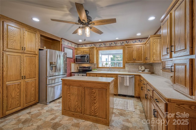 kitchen featuring light countertops, appliances with stainless steel finishes, ceiling fan, and stone finish flooring