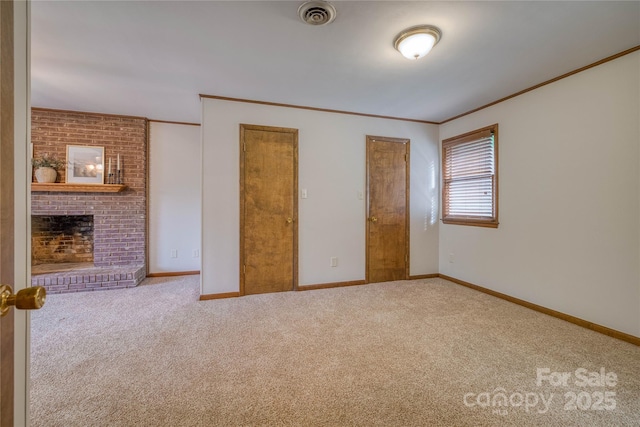 unfurnished bedroom with crown molding, carpet floors, a brick fireplace, and visible vents