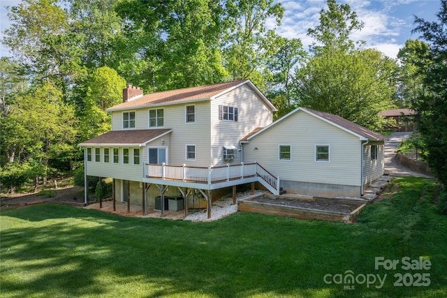 back of property featuring a lawn, a deck, a chimney, and roof with shingles