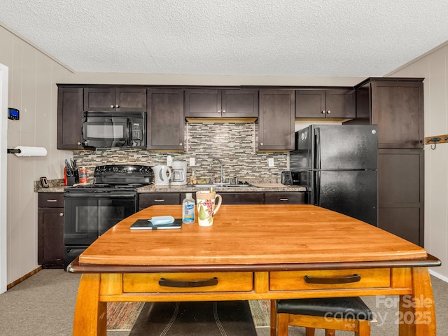 kitchen featuring dark brown cabinets, a sink, a textured ceiling, carpet, and black appliances
